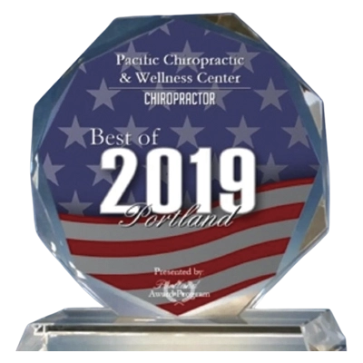 Chiropractic Portland OR 2019 Best Clinic Glass award plaque with blue background, white stars, and red stripes, reading ‘Best of 2019 Portland – Pacific Chiropractic & Wellness Center.